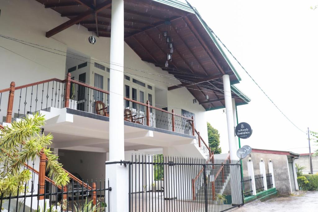 a white house with a balcony and a fence at The kandy downtown in Katugastota