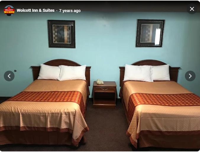 a hotel room with two beds in a room at Wolcott inn and suites in Wolcott