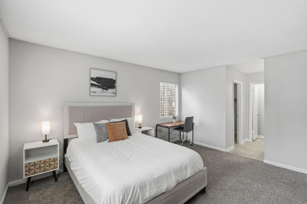 a white bedroom with a bed and a desk at Comfort & Convenience in Stone Mountain in Stone Mountain