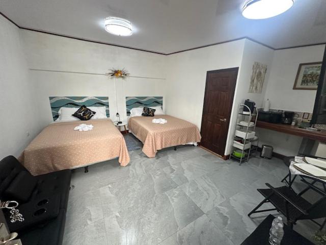 a bedroom with two beds and a dresser at Virginia's apartaments in Omoa