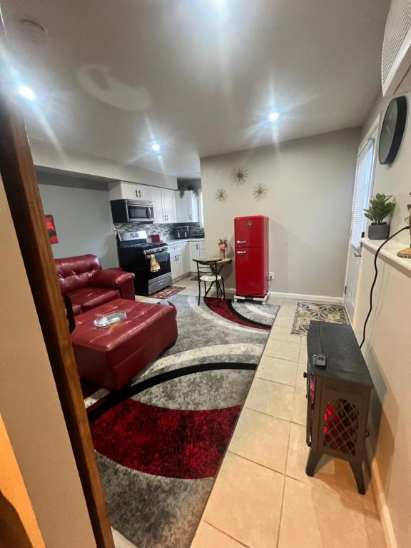 a living room with a red couch and a kitchen at Cozy Cove in Lithonia
