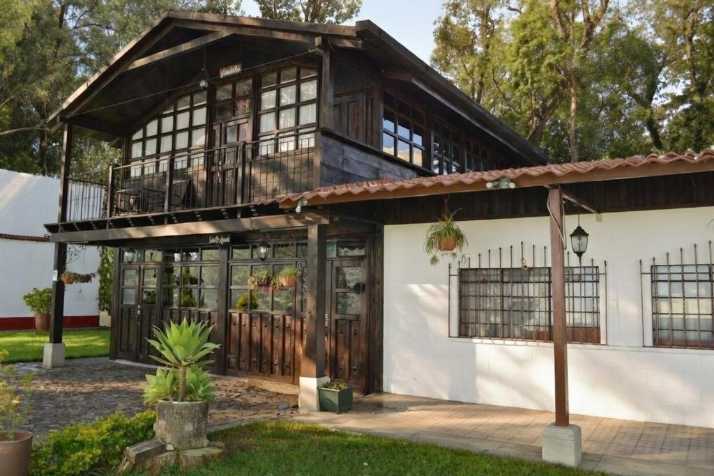 an old house with a porch and a balcony at El Refugio - Hospedaje y Eventos in San Lucas Sacatepéquez