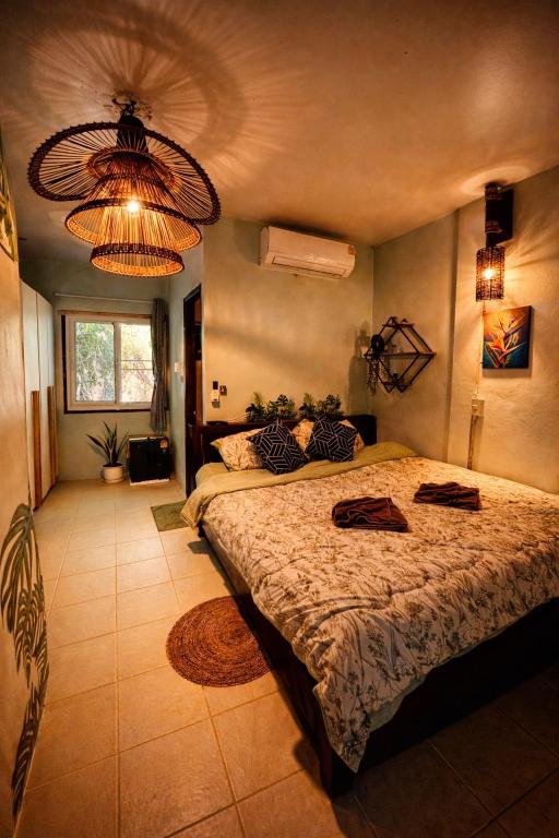 a bedroom with a large bed and a chandelier at MILD ISLAND STAY ROOm in Phi Phi Islands