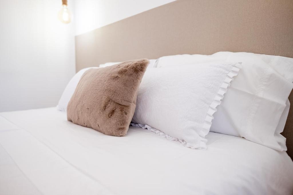 a pillow sitting on top of a bed with white pillows at Portas da Villa in Miranda do Douro