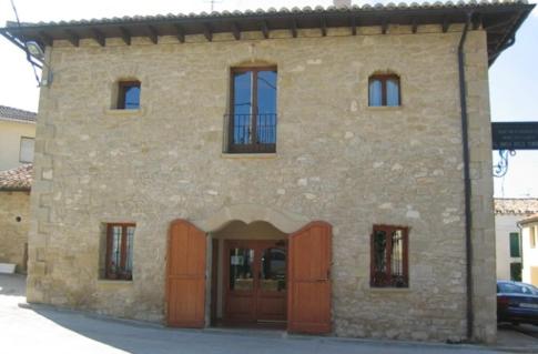 un grande edificio in pietra con porte e finestre marroni di Racó dels Torrats a Torre del Compte