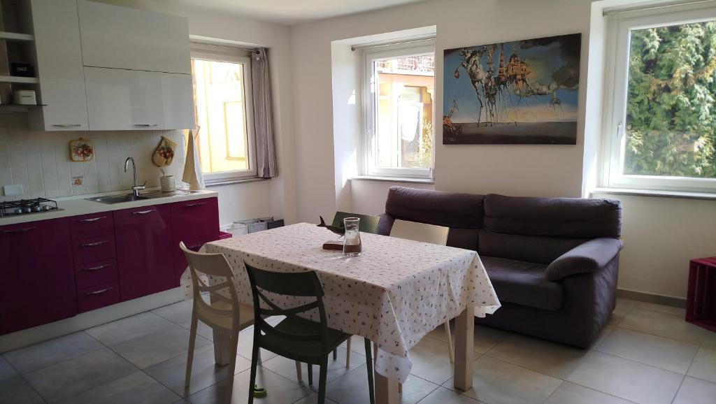 eine Küche und ein Esszimmer mit Tisch und Sofa in der Unterkunft Buonacqua in Tavigliano