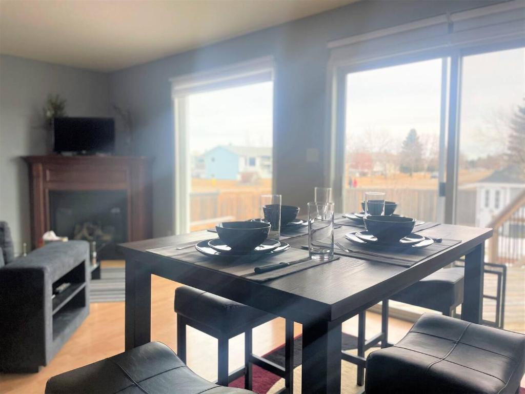 a dining room with a table and chairs and a fireplace at Spacious Duplex in Camrose