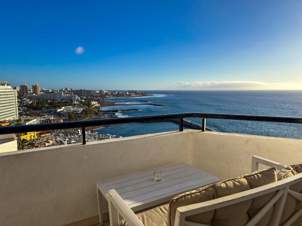 a white table and chairs on a balcony overlooking the ocean at Club Villamar Exclusive Beachfront Penthouse in Adeje