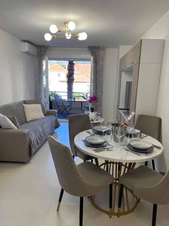 a living room with a table and chairs and a couch at One minute to the Beach in Menton