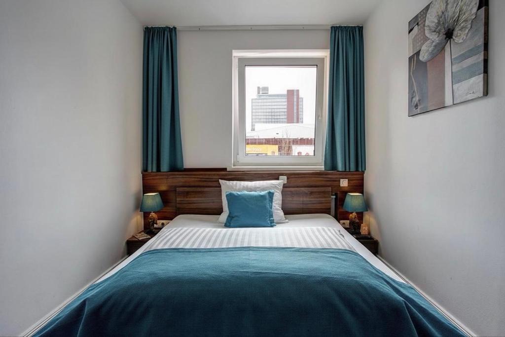 a small bedroom with a bed with a window at North-Hotel in Hamburg