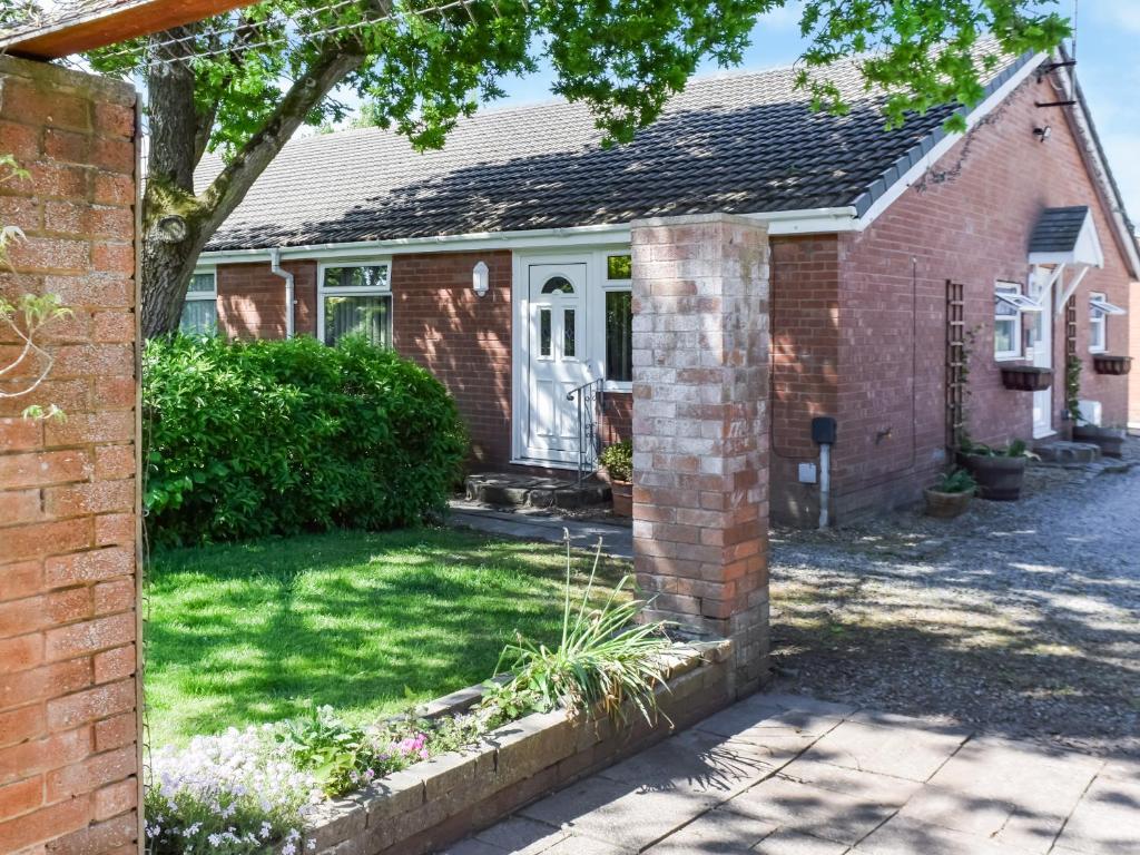 a brick house with a yard with a driveway at Swallow Cottage - Uk49756 in Little Singleton