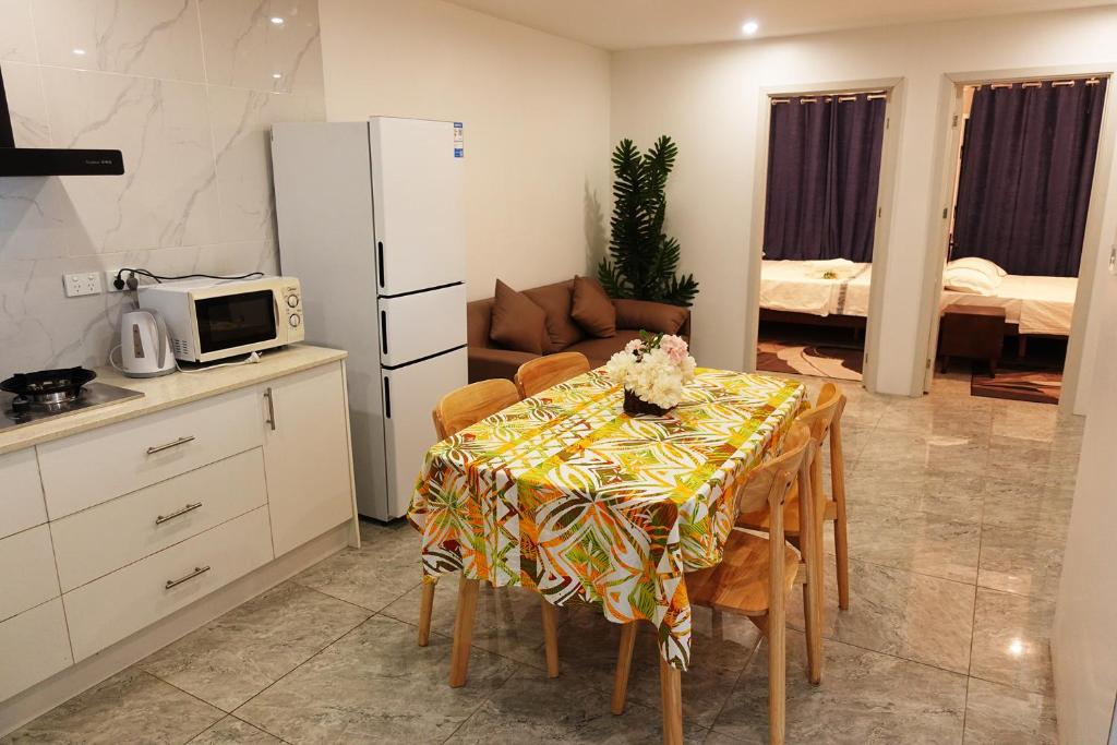 a kitchen with a table with chairs and a refrigerator at Nadi Ease Stay Near McDonalds in Nadi