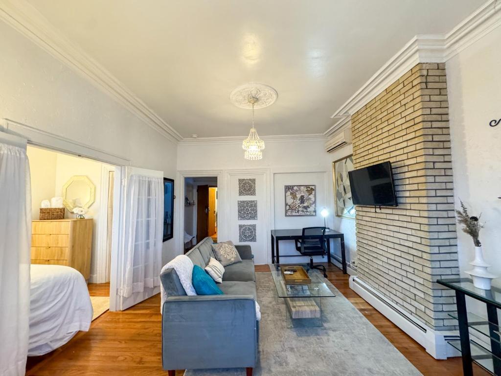 a living room with a couch and a brick wall at Cozy 1Bed, 1Bath in Brookline, MBTA in Brookline