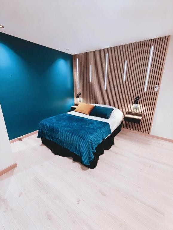 a bedroom with a bed with a blue wall at Ocean Bleu Toulouse in Toulouse