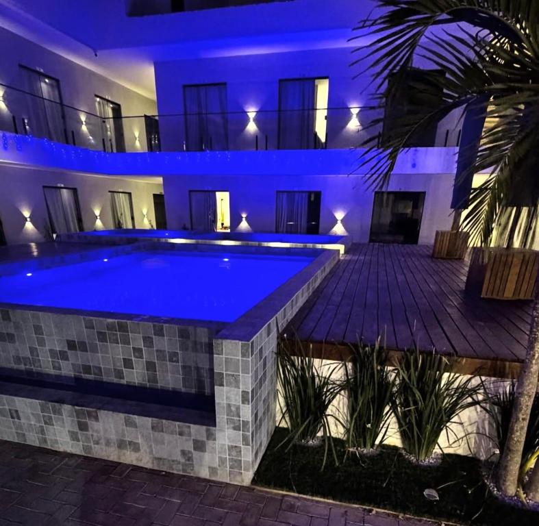 a swimming pool in a building with blue lights at Condomínio Vila Eco Barra apto 215 in Barra Grande