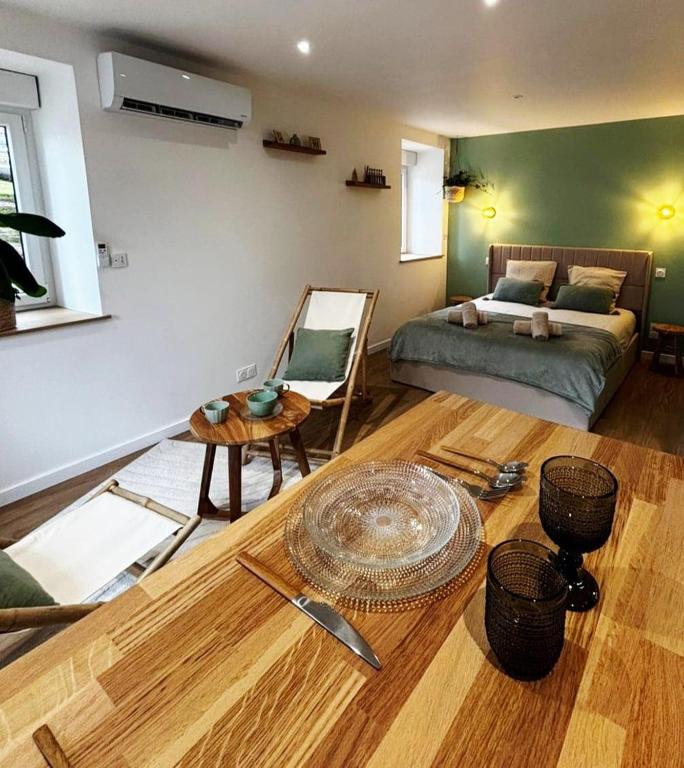 a living room with a table and a bed at La suite canopée en Brocéliande in Campénéac