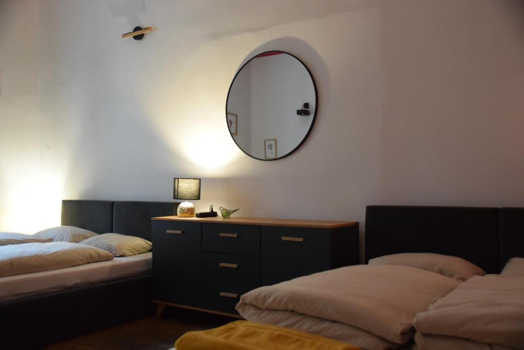 a bedroom with two beds and a mirror on the wall at Apartment Tomasza 8 in Krakow
