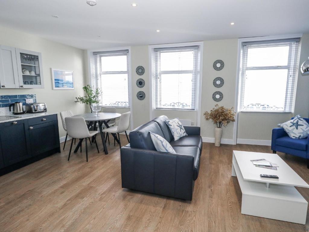 a living room with a couch and a table at Vista Mare 2 in Weymouth