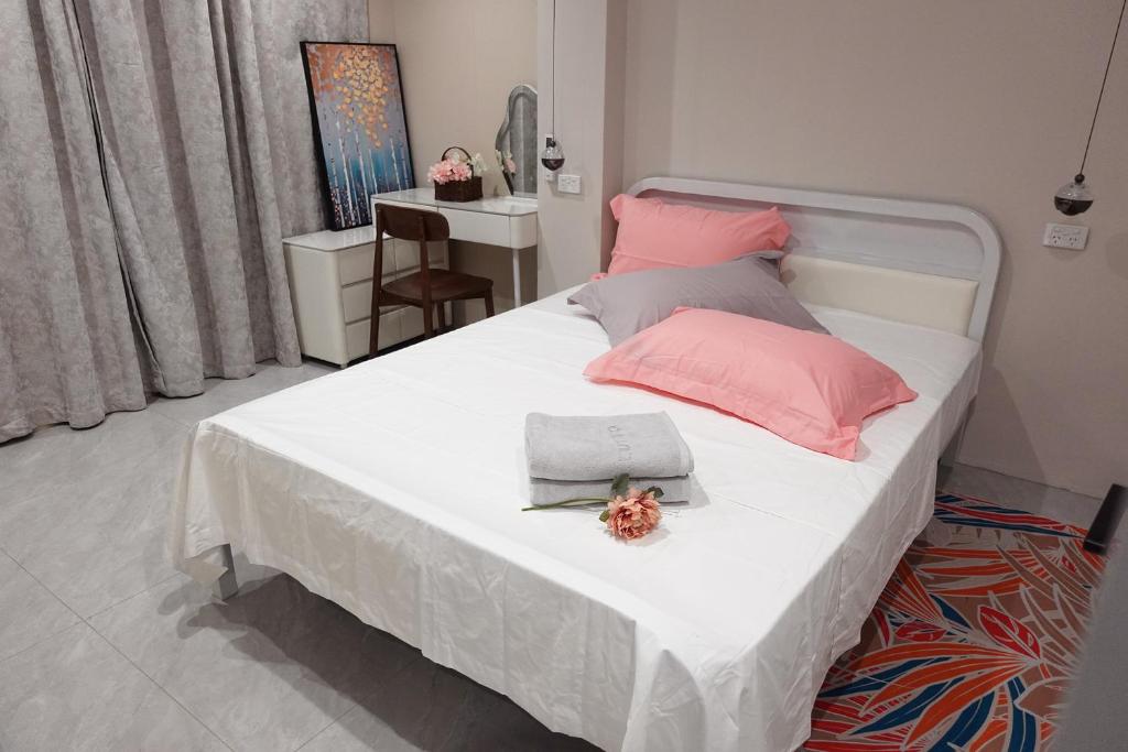 a bedroom with a large white bed with pink pillows at Nadi Easy Home Near McDonalds in Nadi