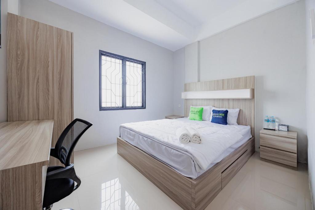 a bedroom with a bed and a desk in it at Urbanview TeBeYe Syariah UNS Solo in Solo