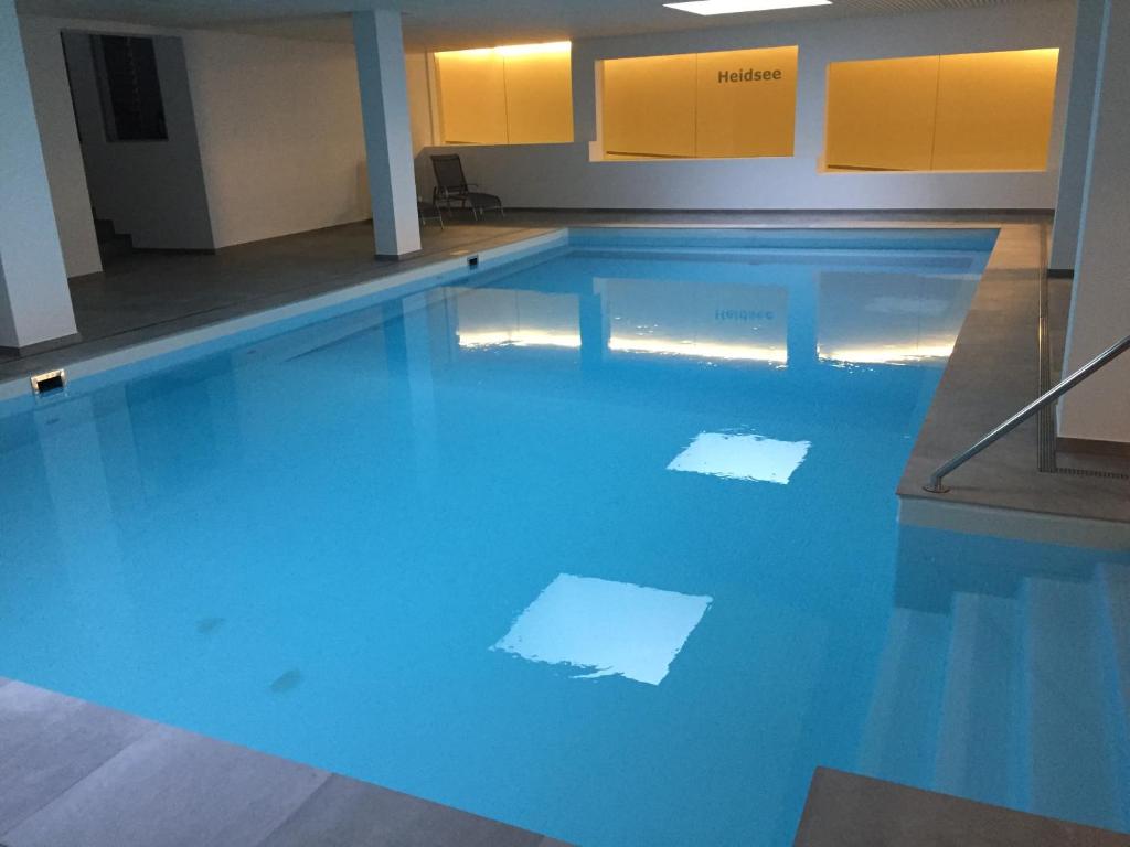 ein Schwimmbad mit blauem Wasser in einem Gebäude in der Unterkunft Mountain Studio, Lenzerheide in Lenzerheide
