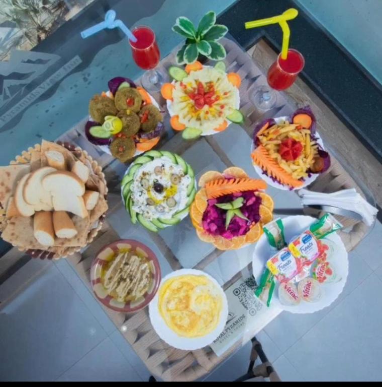 a table filled with different types of food on it at Giza Pyramids& GYM View in Cairo