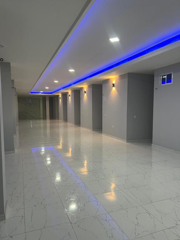 a large empty room with a white floor and blue lights at Serenity House in Santa Marta
