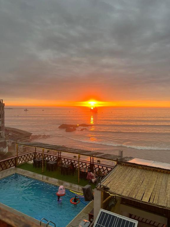 Sonnenuntergang über dem Meer mit Swimmingpool in der Unterkunft Hotel Sunset Chancay in Chancay