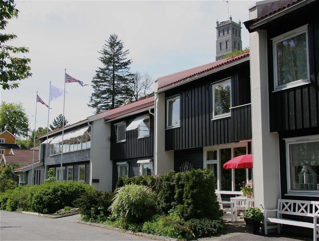 uma fila de edifícios com uma torre de relógio ao fundo em Tønsberg Vandrerhjem em Tønsberg