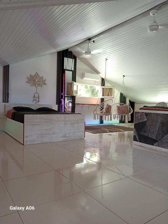 a room with a bed and two chairs in it at Loft haut de villa in Baie-Mahault