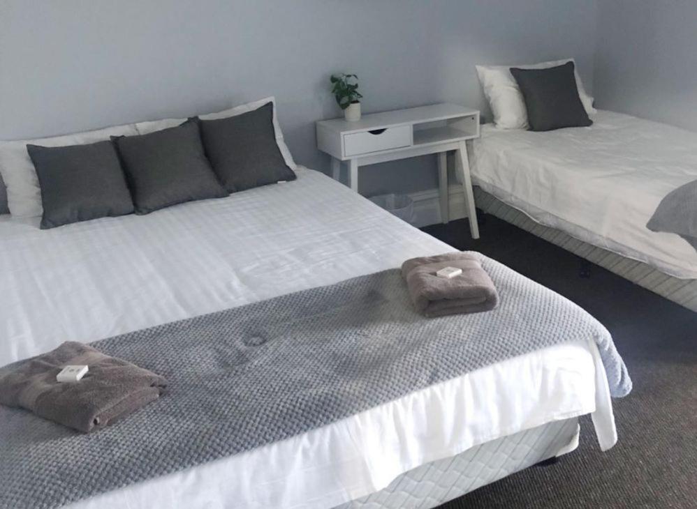 two beds sitting next to each other in a room at white hart hotel murrurundi in Murrurundi