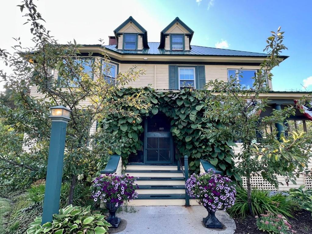 a house with flowers in front of it at Oxford House Inn in Fryeburg