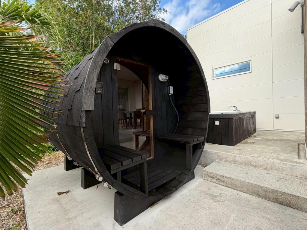 a black iguana house with stairs in front of a building at Villa SUN58 ヴィラサンゴエイト in Miyako-jima