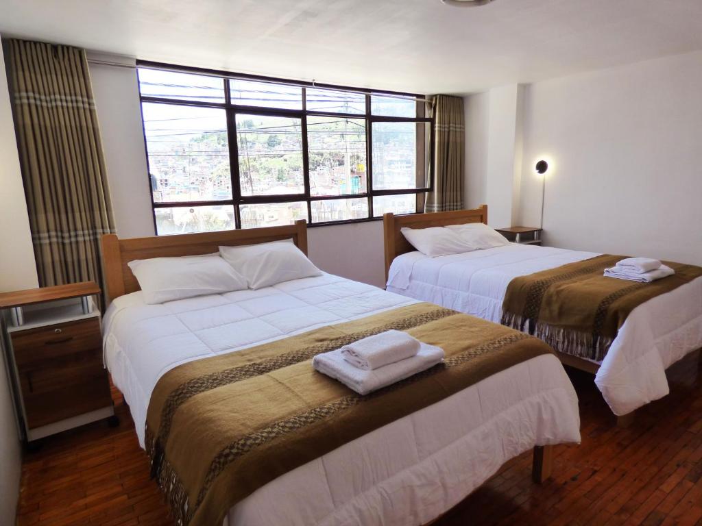 a hotel room with two beds and a window at Tierra Espiritual - Andean Holistic Hotel in Puno