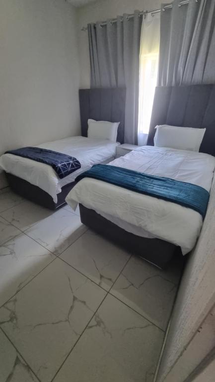 two beds sitting next to each other in a bedroom at 124 On Comet Oaks in Boksburg