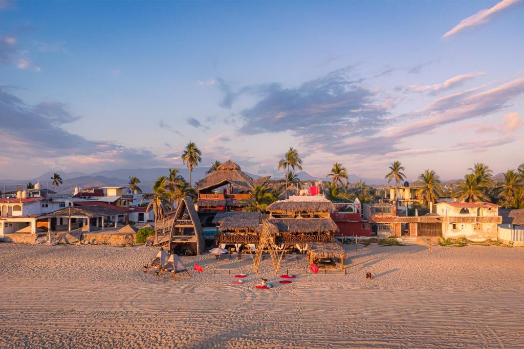 a beach with a group of chairs and palm trees at baXar in Pie de la Cuesta