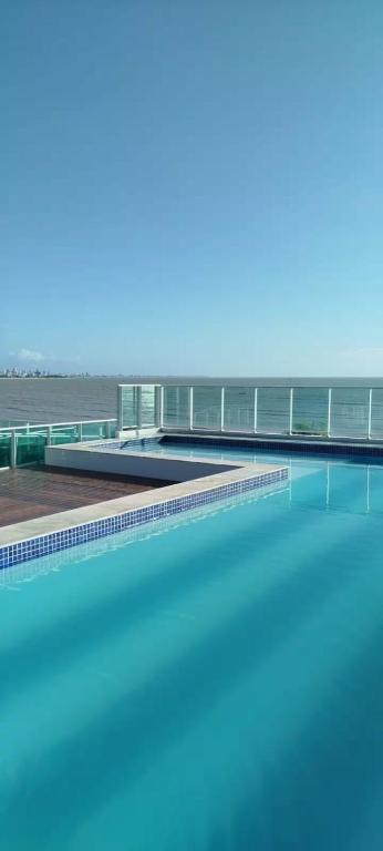 a pool of water with a bridge in the background at Flat Praia Cabo Branco João Pessoa in João Pessoa