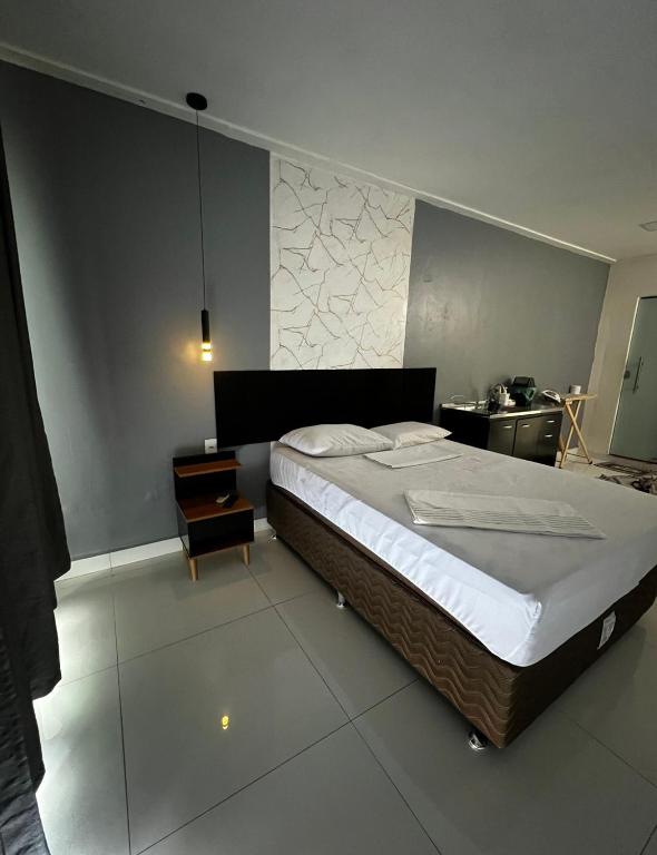 a bedroom with a large bed and a table at Studio 94 in Parauapebas