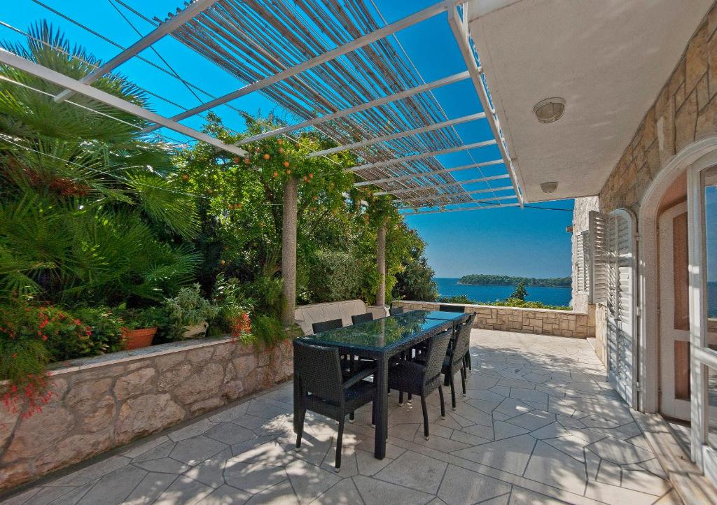 a table and chairs on a patio with a view of the ocean at Holiday Home Ivanino in Dubrovnik