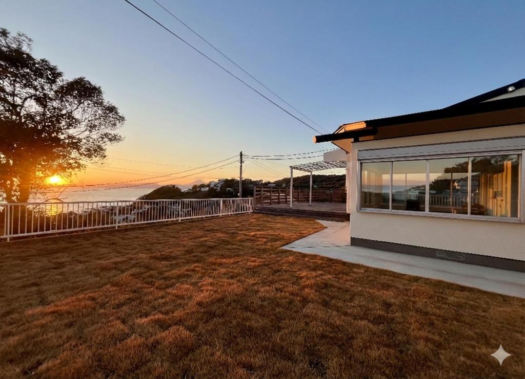 a house with a yard with a view of the ocean at Villa Okubo Akiya in Yokosuka