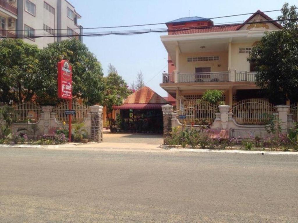 un edificio sul lato di una strada con un edificio di Ta Eng Guesthouse a Kampot