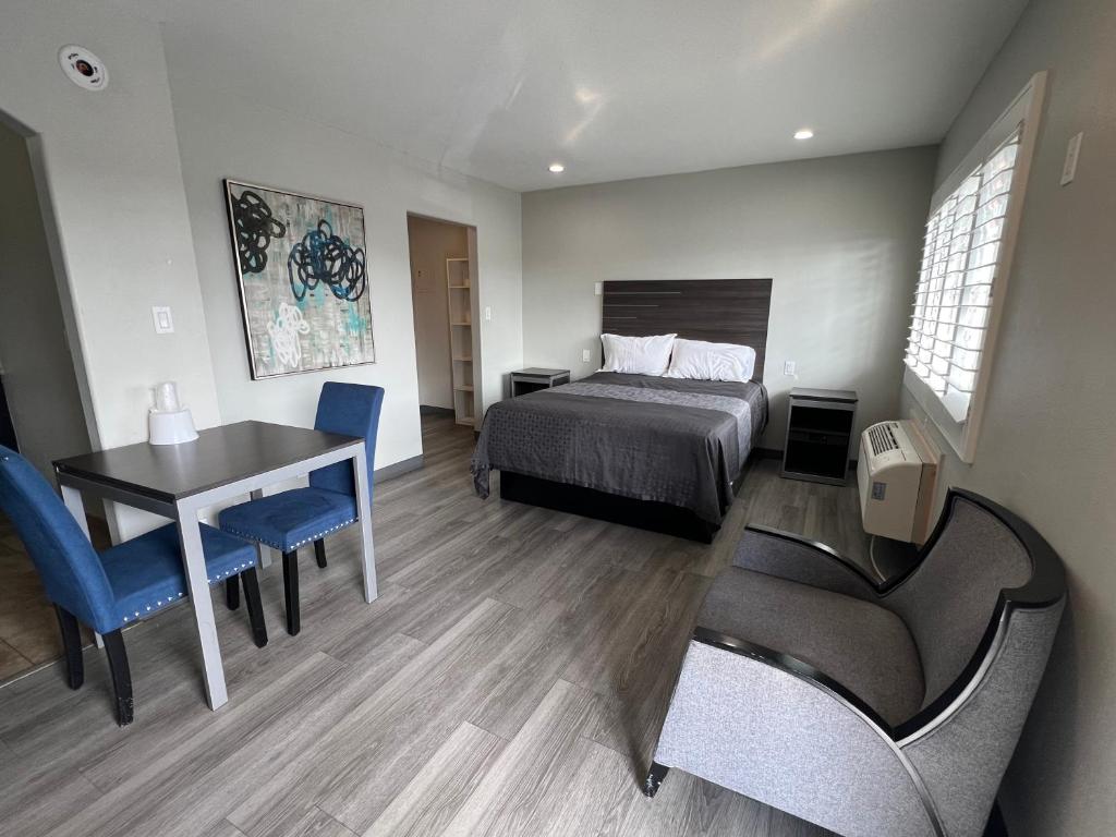 a bedroom with a bed and a table and chairs at Cloud 9 Inn - El Ciello Inn in Pico Rivera