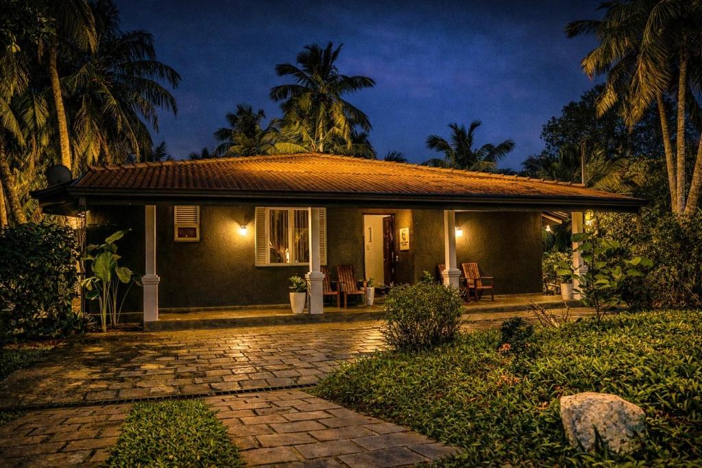 a small house with a stone walkway in front of it at Coco forest camping in Kurunegala