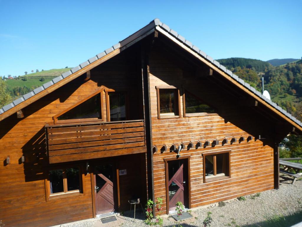 ein großes Holzhaus mit offener Tür in der Unterkunft Les Myrtilles in Le Bonhomme