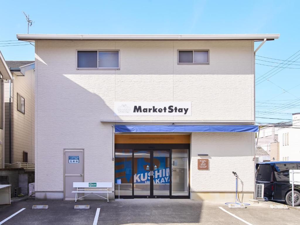 a white building with a marketstay sign on it at マーケットステイ串本 MarketStay Kusimoto in Kushimoto