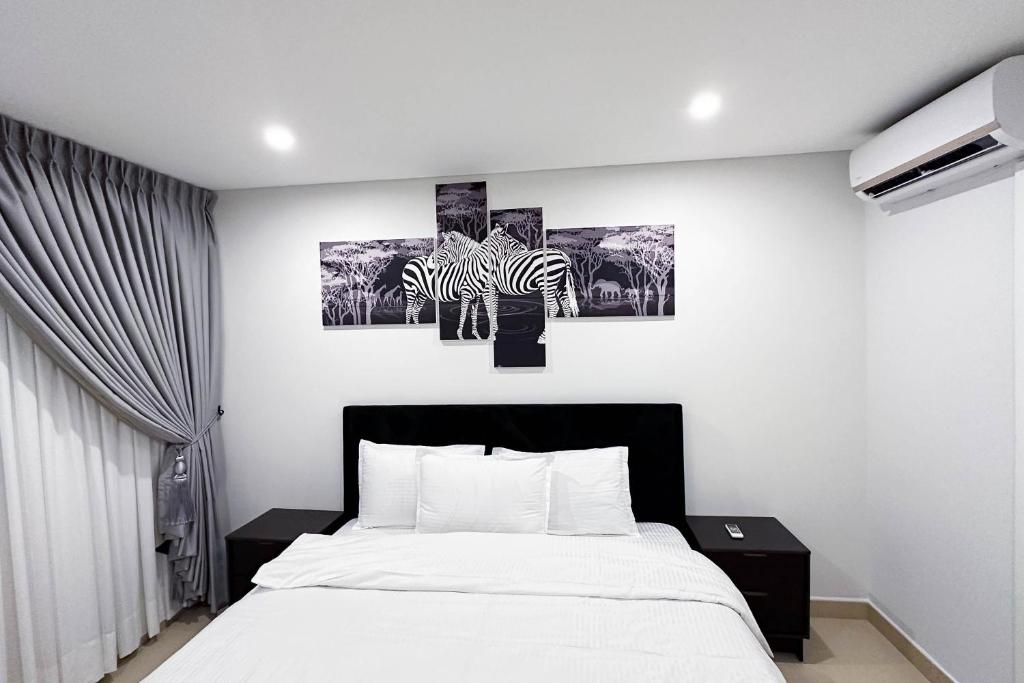 een slaapkamer met een bed en twee zebraschilderijen aan de muur bij Realistic Homes in Accra
