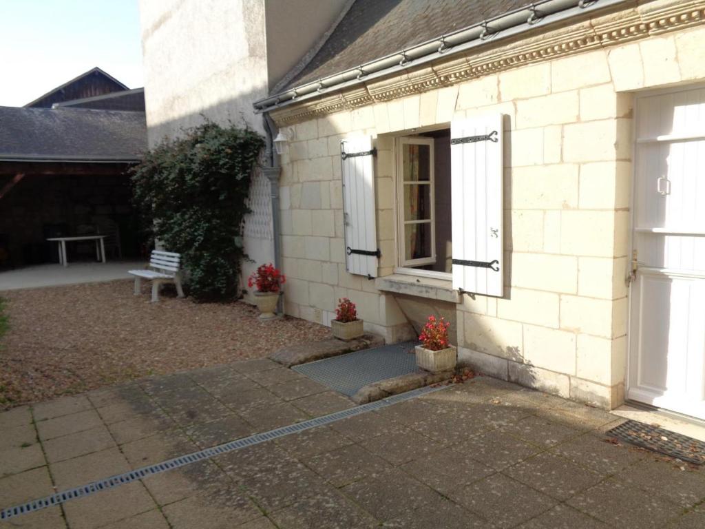 a white brick house with a door and a bench at Maison tourangelle restaurée, 3 chambres, jardin clos, village viticole, proche loisirs et équipements bébé - FR-1-381-236 in Restigné