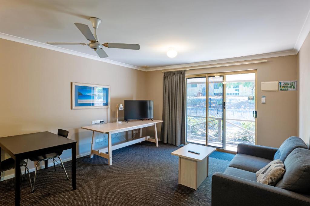 a living room with a couch and a desk and a window at Grandis 35 in Albany