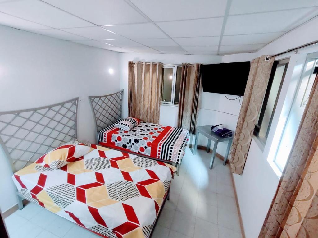 a bedroom with a bed and a table in it at Hospedaje ANDRES & COCHERA in San Antonio