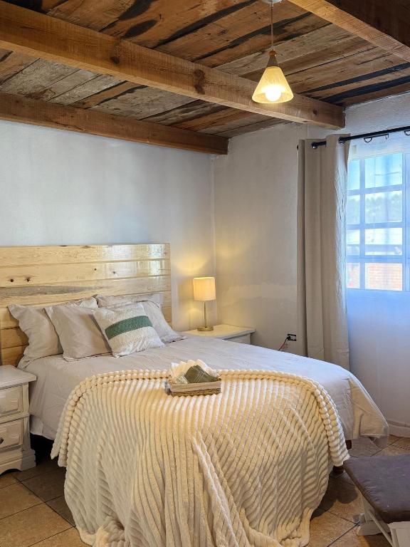 ein Schlafzimmer mit einem großen Bett mit hölzernem Kopfteil in der Unterkunft Casa Chepe in Creel
